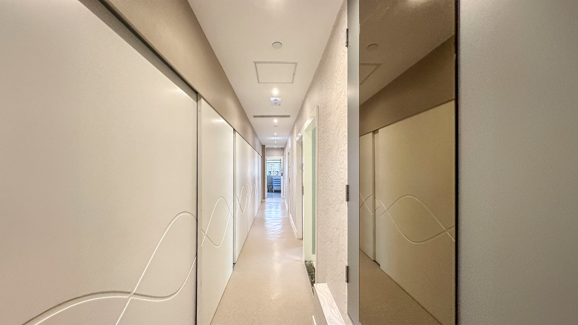 寬敞的美容中心等候區,配有白色沙發和冷凍溶脂設備的宣傳牆,突顯舒適與專業的氛圍。